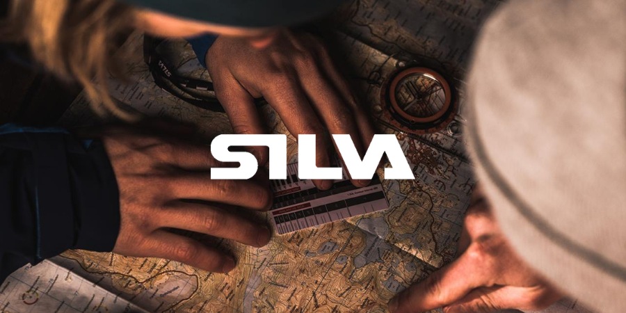 Randonneurs utilisant une boussole Silva pour s’orienter sur une carte topographique.